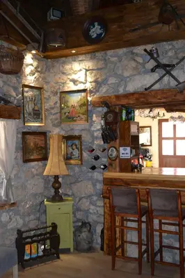 a room with a stone wall with a table and chairs at Peuta Hill in Stara Zlatica