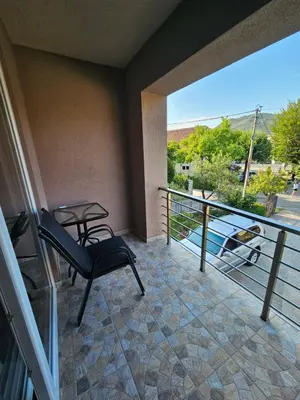 a balcony with a chair and a table and a view at Apartment Anita Cetinje in Cetinje