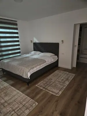 a bedroom with a bed and two rugs on the floor at Apartment Anita Cetinje in Cetinje