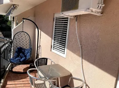 a porch with chairs and a table and a window at Magnolia Apartment in Budva