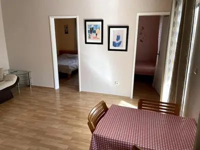 a dining room with a table and a bedroom at Magnolia Apartment in Budva