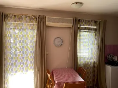 a room with a table and a clock on the wall at Magnolia Apartment in Budva