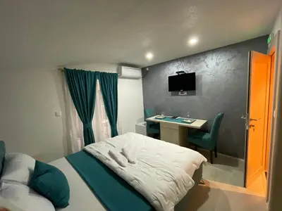 a small bedroom with a bed and a desk at Apartments Zejak in Mitrovići