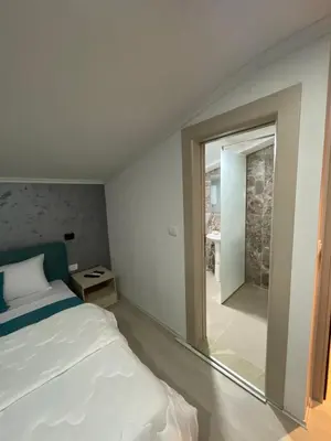 a bedroom with a bed and a sliding glass door at Apartments Zejak in Mitrovići