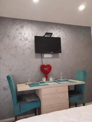 a room with a desk with two chairs and a tv at Apartments Zejak in Mitrovići