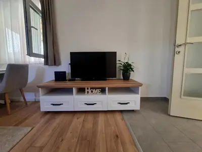 a living room with a tv on top of a cabinet at Apartment Matija Airport in Podgorica