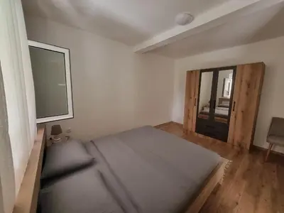 a bedroom with a large bed and a window at Apartment Matija Airport in Podgorica