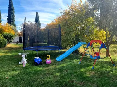 a playground with a slide and a swing at Apartment Matija Airport in Podgorica