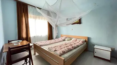 a bedroom with a bed and a table and a window at Happy Home in Lastva