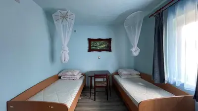 a room with two beds and a table and a window at Happy Home in Lastva