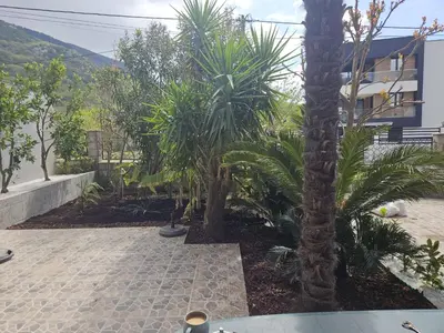 a courtyard with palm trees and a building at Happy Home in Lastva