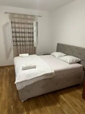 a bed with two towels on it in a room at Viktor Apartman in Podgorica