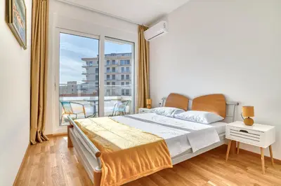 a bedroom with a bed and a large window at Ivanovic residences in Budva