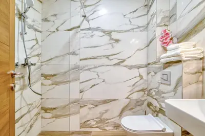 a bathroom with a marble shower and a toilet at Ivanovic residences in Budva