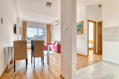 a dining room and living room with a table and chairs at Ivanovic residences in Budva