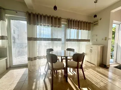 a dining room with a table and chairs and windows at Blue Sky Villa in Brca