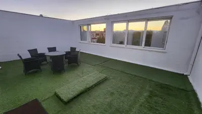 an empty room with a table and chairs and windows at City Center Relax Podgorica in Podgorica