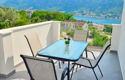 a blue table and chairs on a balcony with a view at Sunny apartment Tara in Kotor