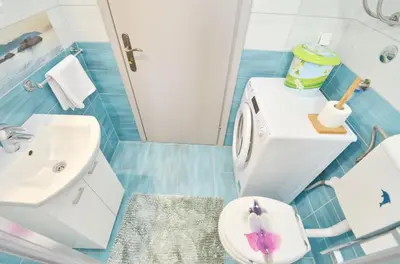 a blue and white bathroom with a toilet and a sink at Sunny apartment Tara in Kotor