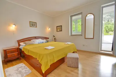 a bedroom with a bed with a yellow bedspread at Sunny apartment Tara in Kotor