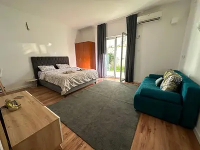 a living room with a blue couch and a bed at Apartment Simona in Budva
