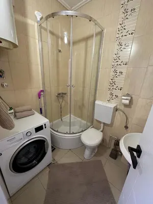 a bathroom with a shower and a washing machine at Apartment Simona in Budva