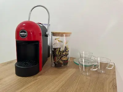 a red coffee maker sitting next to glasses on a table at Apartment Simona in Budva