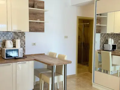 a kitchen with a table with chairs and a microwave at Viola Di Mare Apartments in Budva