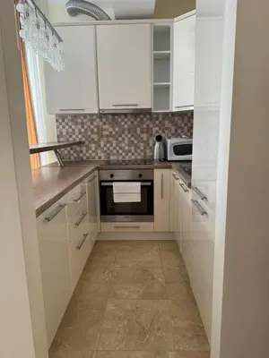 a kitchen with white cabinets and a stove top oven at Viola Di Mare Apartments in Budva