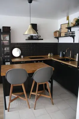 a kitchen with a wooden table and two chairs at cozy family apartment in Cetinje