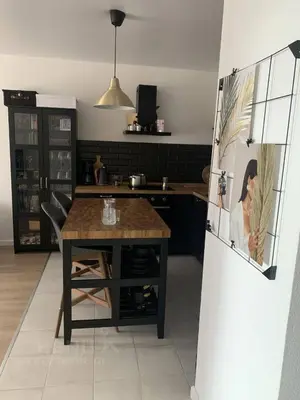 a kitchen with a table and a refrigerator at cozy family apartment in Cetinje