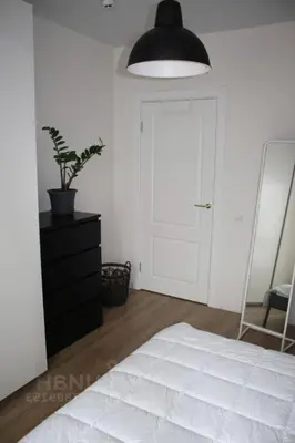 a bedroom with a white bed and a black lamp at cozy family apartment in Cetinje