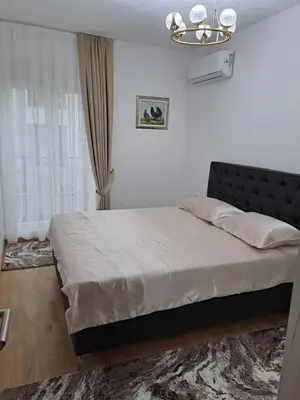 a bedroom with a large bed with a black headboard at Apartman Vlado Podgorica 2 in Podgorica