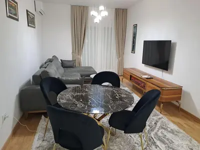 a living room with a couch and a table and chairs at Apartman Vlado Podgorica 2 in Podgorica