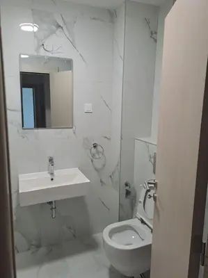 a white bathroom with a sink and a toilet at Apartman Vlado Podgorica 2 in Podgorica
