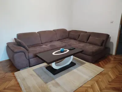 a living room with a brown couch and a coffee table at Vrsutska 81 in Sutomore