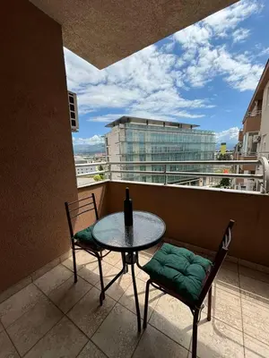 a table and two chairs on a balcony with a window at Apartman 38 in Podgorica