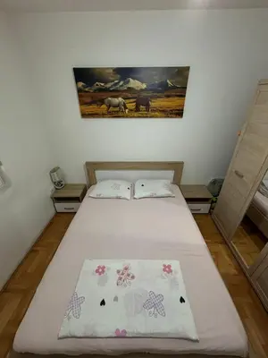 a bedroom with a bed and a painting on the wall at Apartman 38 in Podgorica