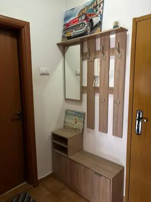 a dressing room with wooden shelves and a mirror at Apartman 38 in Podgorica