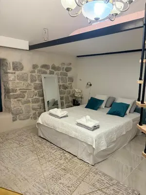 a bedroom with a large bed with blue pillows at Casa Behar in Kotor