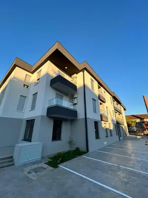 a large white building with a parking lot at Apartman Princeza Ksenija in Podgorica