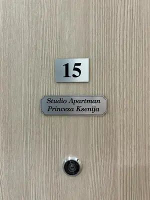 a sign on a wooden door with the number at Apartman Princeza Ksenija in Podgorica