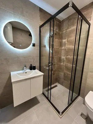 a bathroom with a shower and a sink and a mirror at Apartman Princeza Ksenija in Podgorica