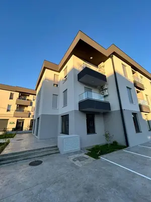 a large white building with a parking lot at Apartman Princeza Ksenija in Podgorica