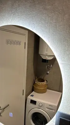 a laundry room with a washing machine and a mirror at Apartman Princeza Ksenija in Podgorica