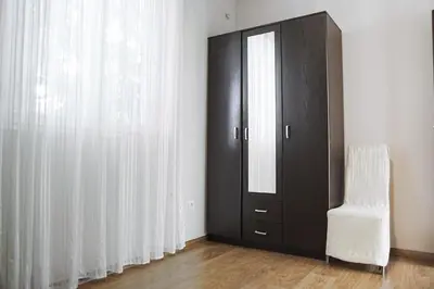a room with a black cabinet and a white chair at Lemon Villa in Bar