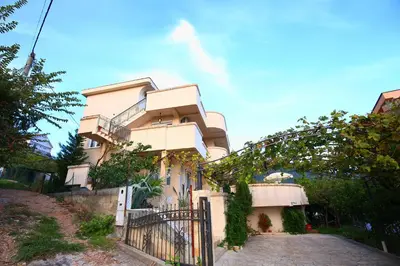 a white building with a gate and a fence at Lemon Villa in Bar
