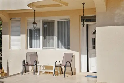 two chairs and a table in front of a house at Lemon Villa in Bar
