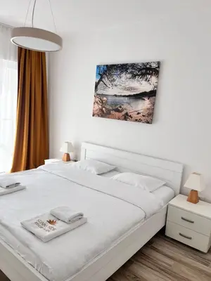 a bedroom with a white bed and a painting on the wall at Your Sunny vacation in Budva