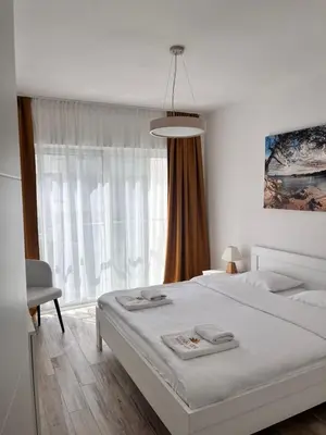 a white bedroom with a large bed and a window at Your Sunny vacation in Budva